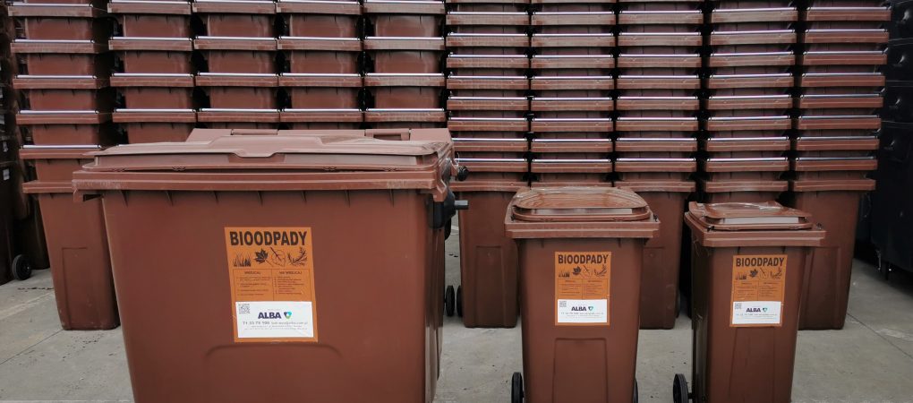 Stos brązowych pojemników na odpady bio. Pojemniki w trzech różnych wielkościach.